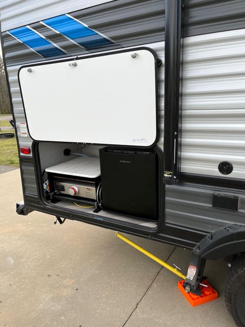 Exterior propane griddle with mini fridge to store drinks or ingredients for cooking. 