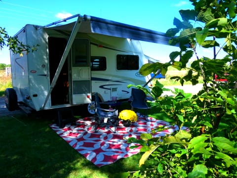Large awning, outdoor carpet and camping chairs.