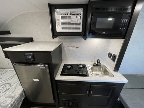 2 Burner Cooktop, Microwave, Built-in Sink w/ Integrated Faucet, Fridge and freezer. We have added a TV too!