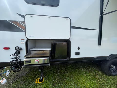 Outdoor kitchen. Includes mini fridge, griddle, fresh water hose. 