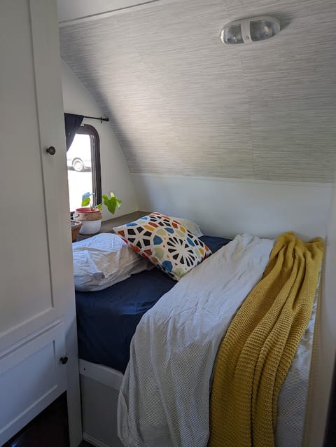 Cozy primary bed with two windows, reading light, and privacy curtain. All linens included. 