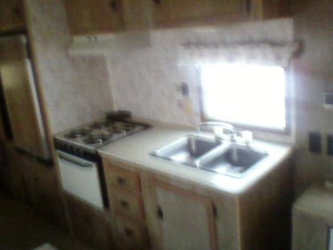 Full kitchen with stove, oven, sink and fridge.