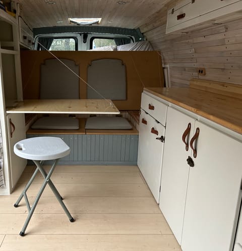 The bed folds up to reveal a seat for 2 people. The table folds down - and there is a stool if you prefer to sit face-to-face. 