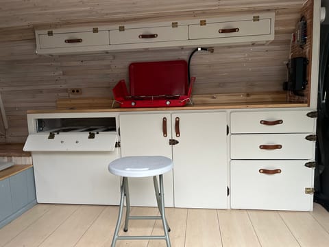 The 2-burner stove is stored above the fridge. Our kitchen is designed to be used seated. 