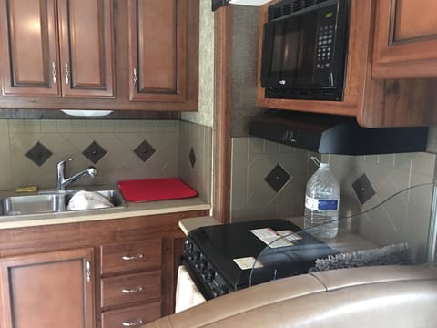 Kitchen with sink, oven, stove top and microwave with hood vent