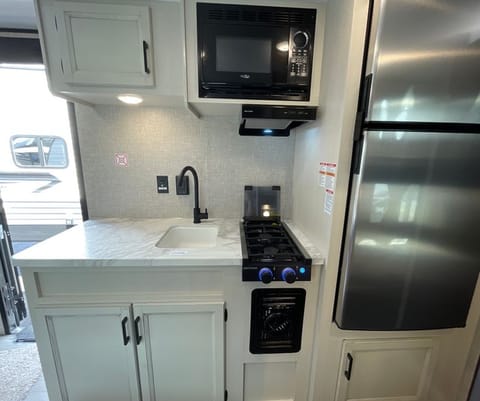 Kitchen with lots of counter space! high rise faucet, microwave oven, 2-burner stove top.