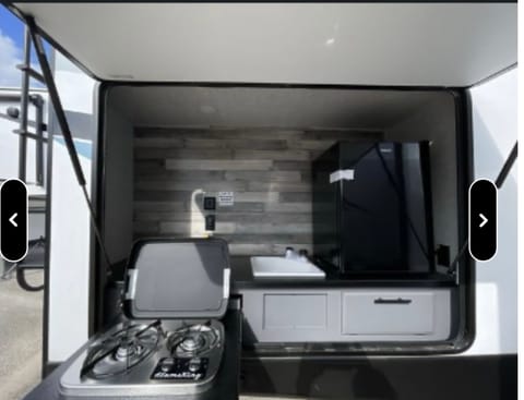 Outdoor kitchen with sink, fridge and outdoor stove.