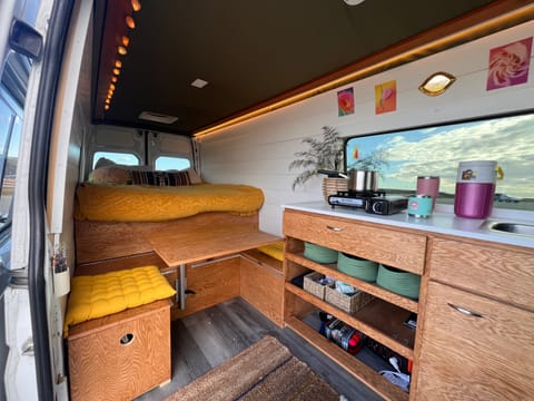 Queen sized bed, dining table that converts to a bunk bed, kitchen equipped with a sink and gas stovetop
