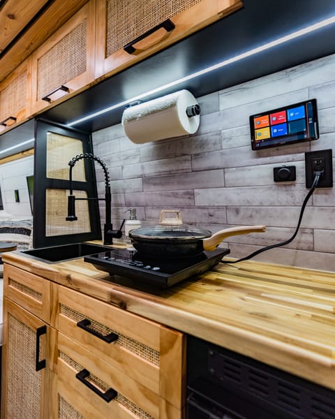 A view of the portable induction cooktop. Simply turn on your inverter, plug in, and turn on to use. This can also be plugged into the exterior of the van to cook next to a fire! Whakaari also comes with a butane portable stove so you have 2 places burners!