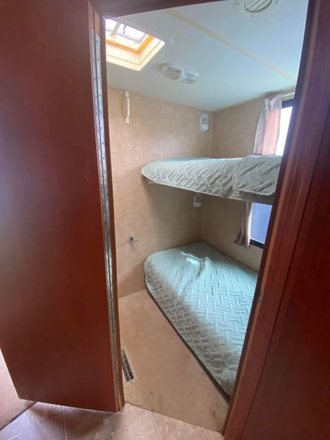 Second bedroom is a private bunkbed room with TV, 3 drawer dresser and more storage under the lower bed. 