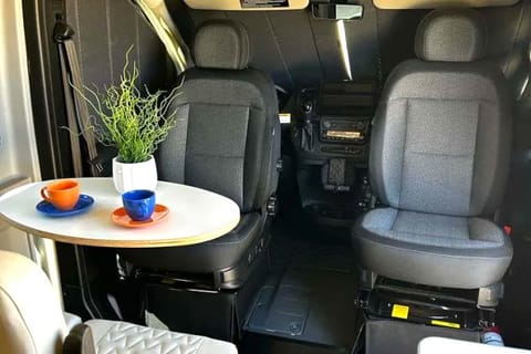 Indulge in cozy and functional seating arrangements with our RV's rear seats featuring a removable dining table and swivel capabilities for the driver and passenger seats. This versatile setup allows up to four people to gather comfortably around the compact table, creating the perfect space for meals, board games, or lively conversations.