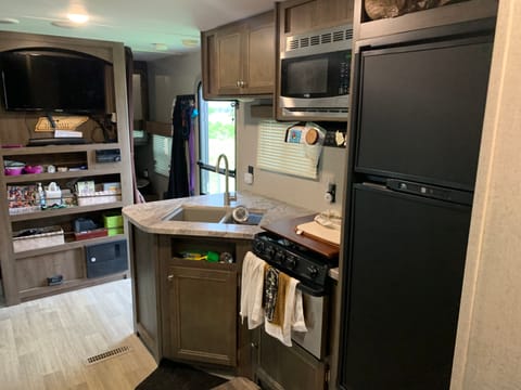 A nice look at the kitchen area, double tub sink, three burner gas stove, gas oven, a spacious refrigerator.  Everything you need to prepare your  favorite meals or snacks all day and night.