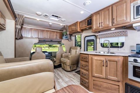 Front of RV showing the driving area with double bed above the cab area.