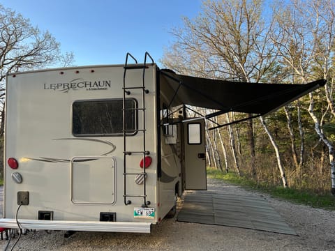 Large awning , exterior plugs, outdoor camping mat.  This little RV packs a lot in a small space.