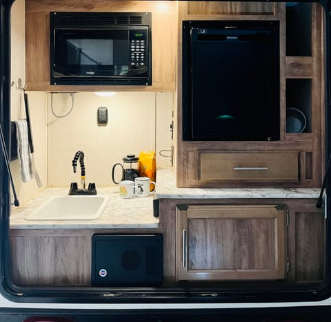 Prepare meals and keep drink cold in the kitchenette located in the rear of the camper. 