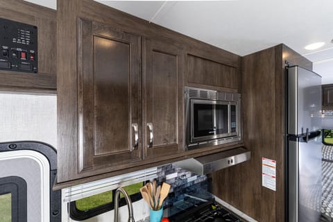 Kitchen cabinets, microwave, oven and fridge.