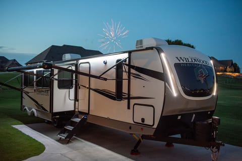 Features vacuum-bonded “aluma frame” sidewalls and floor, 200-watt solar panels on the roof, baggage door magnets, and easy-pull slam latches.