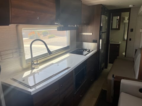 Double stainless steel sink with covers that reverse into cutting boards.  Ample counter space for meal prep & both cabinets and drawers for storage.