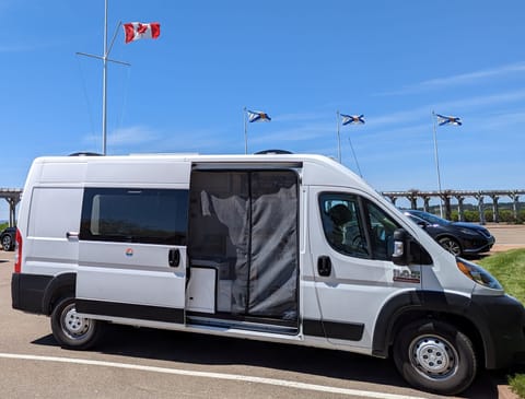 Passenger-side view; sliding door open; magnetic bug-screen closed. Note how easily we fit into standard parking space at a Canada Visitor Center!