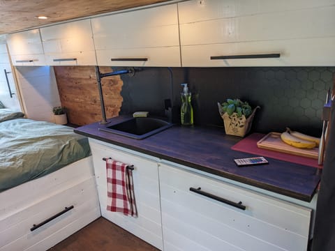 Modern kitchen with sink & under counter pull out fridge.