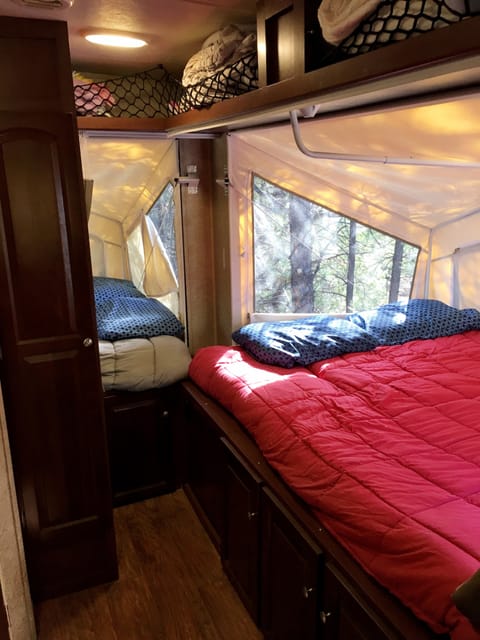 Interior back two queen size beds.  The canvas and screen zip open allowing for an open air tent-like feel.  Both beds have ample storage both below and above.  Beds have mattress warmers and attachable fans/lights.  There are also privacy curtains.