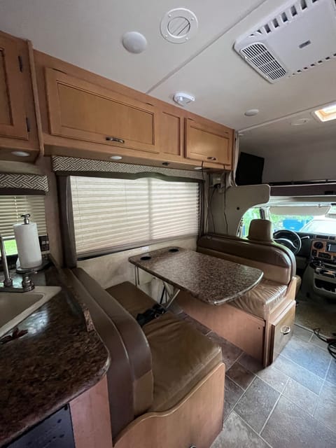 Comfy bench breakfast nook! Table folds down to make additional sleeping area.  Storage above has DVD player and kids books 