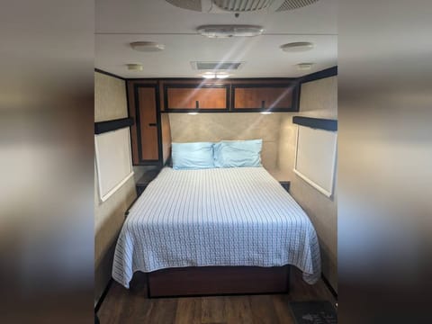 Queen Bed with closet on the left and overhead cabinets
