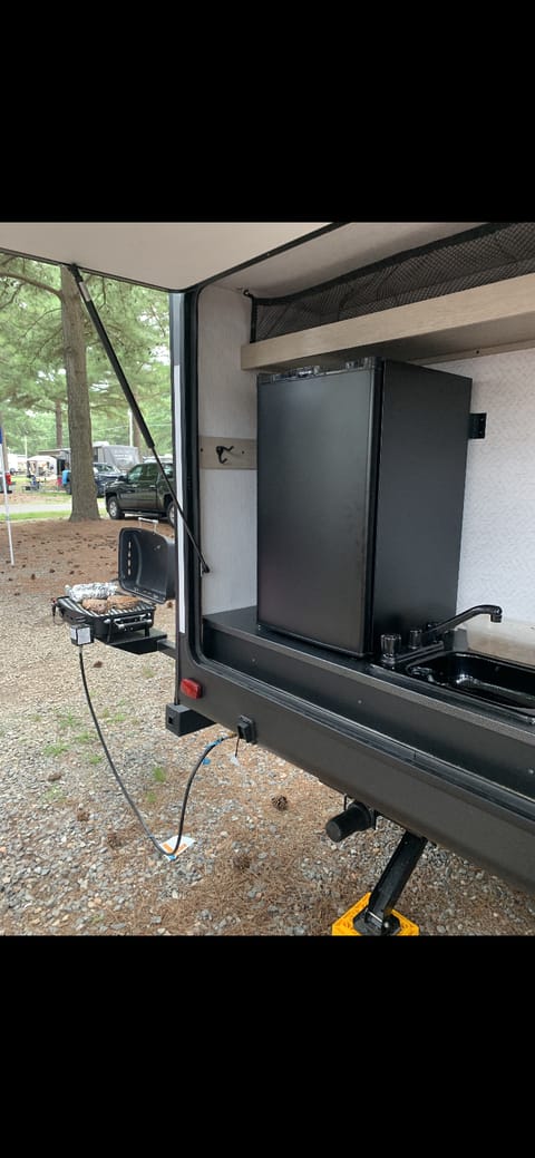 Outdoor kitchen.  Fridge, sink and attached grill.  