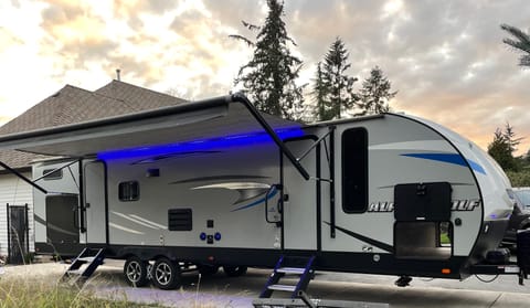 Outside photo of camper with Blue LED lights on. 