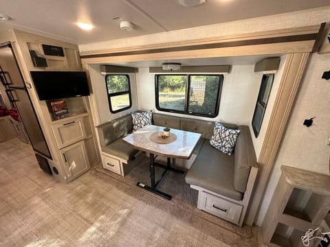 The dinette offers seating for about 6 people, with windows all around that can be covered with a pull-down shade. The TV can change angles as well.