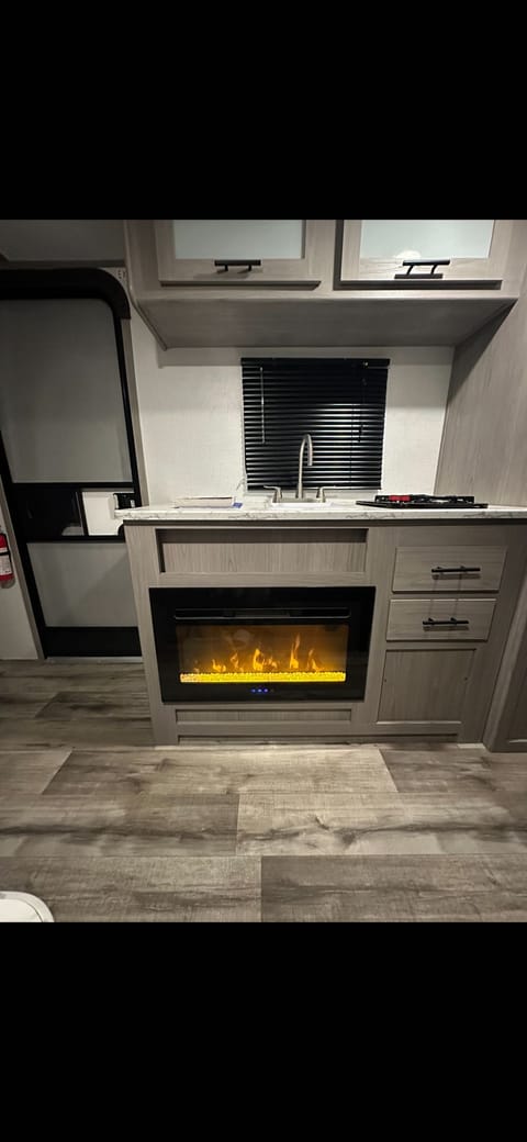 The beautiful kitchen with a fully electric fire place that heats the camper up in no time!