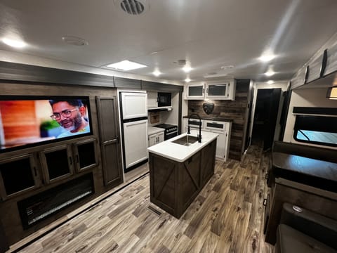 Inside Living area, looking towards front of trailer.  Dining booth and kitchen view