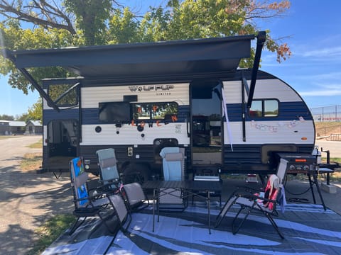 Outside view with all of the included camping gear. 4 chairs, Blackstone griddle, outside rug, outside table and TV.