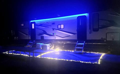 Exterior view at night with lighted edge exterior rugs that plug into RV electrical.