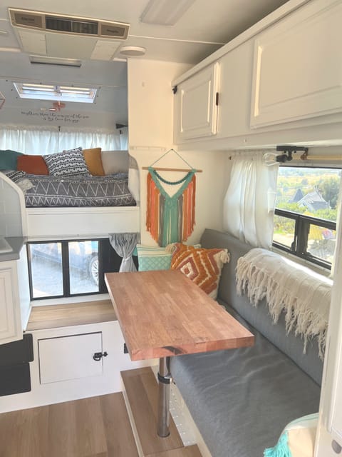 Folding full bed & cabinet bunk bed overhead. Table comes out & has a foot to use outside in campsite, along with two metal white stools (not pict.)