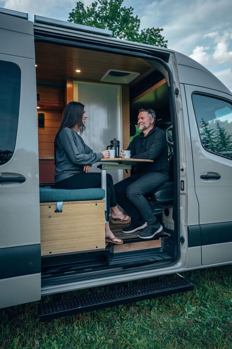 The dining area in the Zion van is the perfect spot to enjoy a relaxing meal or sip on a warm cup of coffee. With every rental, we provide our Road Trip Roast coffee along with french press, so you can start your mornings off right with a fresh brew. The cozy dining setup, featuring a swivel table and comfortable seating, creates an inviting space for enjoying your coffee while taking in the scenic views. 