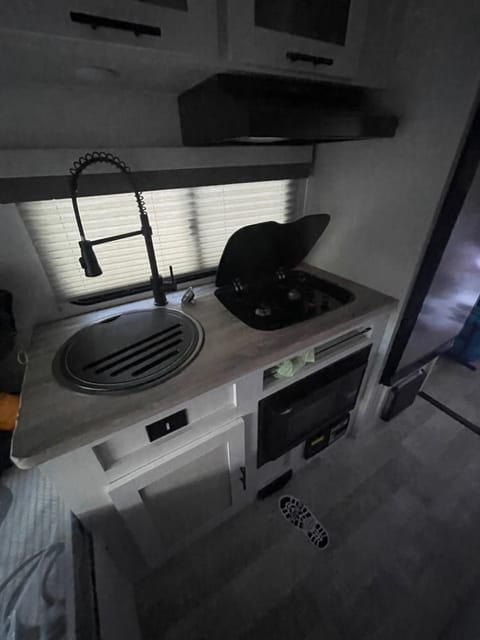 Kitchen area, deep sink, two burner cook top, microwave and fridge/freezer