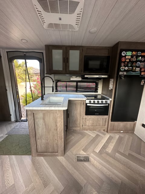 A full kitchen, with oven, gas range, refrigerator, freezer, sink, microwave, and cooking supplies.