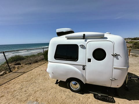 Marshmallow, our HC1 from Happier Camper. This tiny camper boasts a retro design and surprisingly spacious interior. Modular like LEGO, crafted from lightweight fiberglass, and easily towable by most cars, Marshmallow is calling all adventurers.