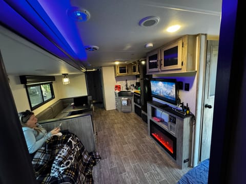Walking in with a spacious hallway where the couch and U-shape dinette slide out making it easy to move about! The Electric fireplace gives off different colors and will warm the entire camper up!