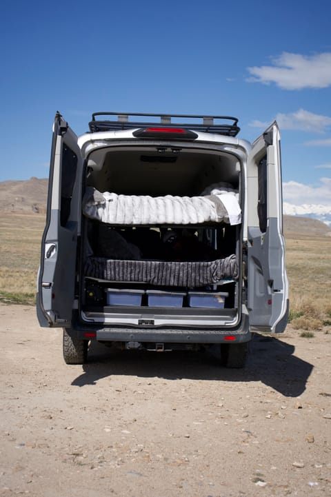 View from the back - three storage bins under beds and two bunk beds with fresh bedding.