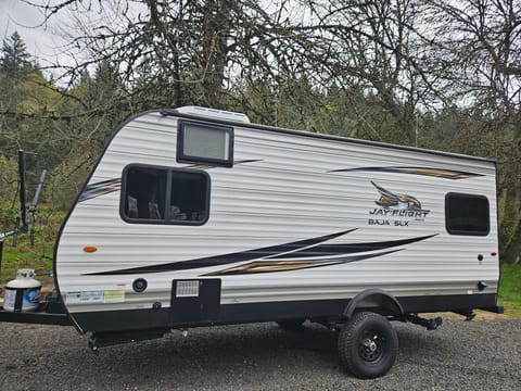 Driver's side of the trailer.  Integrated AC unit is located over the queen bed.  Higher up on the axle.  Easy access to the single gray/black dump connection.  Sturdy jacks with large pads.