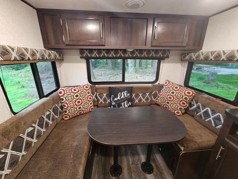 Three large windows providing plenty of incoming light and views.  Comfortable U-dinette with vent above.  Perfect space for reading or playing games. 
 Storage cabinets with easy access.  Table converts into a bed.