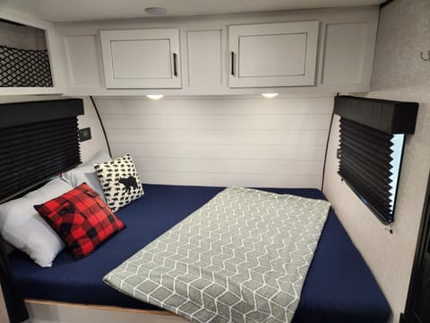 Queen size bed with storage underneath and over head.