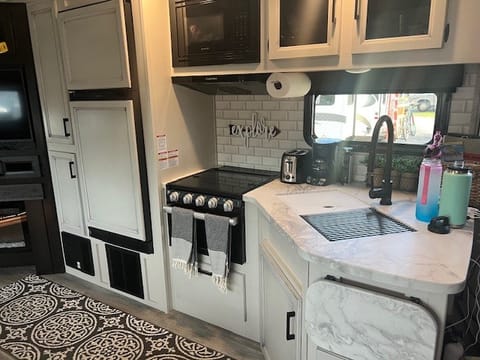 Farmhouse inspired kitchen with double sink, gas stove and burners. Large fridge, freezer and microwave! Lots of storage for food in cabinets.