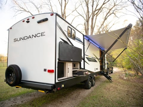 Comfort meets outdoors with this 2022 Sundance. Enjoy all of the amenities of home but in the great outdoors. Listen to music inside or out with the 2-zone speaker system. Sleeps 10: 2 comfy bedrooms (one with a Queen bed and one with 3 bunks); a booth that turns into a bunk; a convertible kitchen table; a couch that pulls out into a bed. Full-size shower and plenty of space for everyone with a big slideout. Lights everywhere for at night and an outdoor cooking griddle built-in with plenty of storage and an outdoor fridge too! 