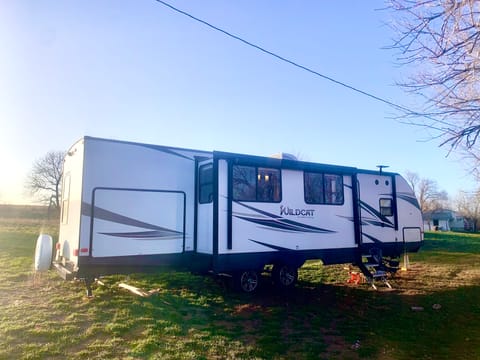 Exterior passenger side. Back hatch is outdoor kitchen. Front hatch is pass through storage. One slide out and two awning 