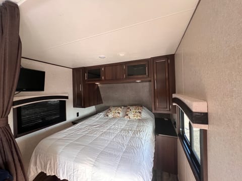 Primary queen size bed fitted with white cotton sheets and hotel bedding for a comfortable evening.  Walk around bed with side tables, usb chargers.  Bedroom area has it's own television. 