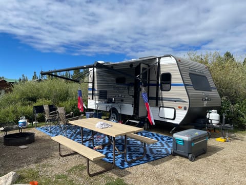 Camper with awning and outdoor setup.