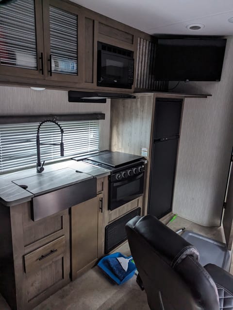 This kitchen is equipped with a sink, stove, microwave, and oven. It has a large refrigerator and plenty of cabinet space. Pots, pans, utensils for cooking and eating are provided with this rental.